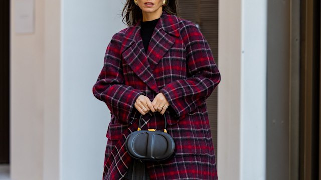 BARCELONA, SPAIN - NOVEMBER 09: Zina Charkoplia wears red navy checkered Dior coat, grey pleadet Frankie Shop mini skirt, black Massimo Dutti sweater, knee high black Blanc sur Blanc boots, black Dior bag on November 09, 2023 in Barcelona, Spain. (Photo by Christian Vierig/Getty Images)