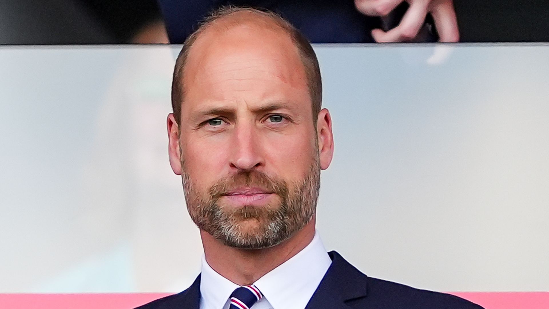 Prince William in suit watching football