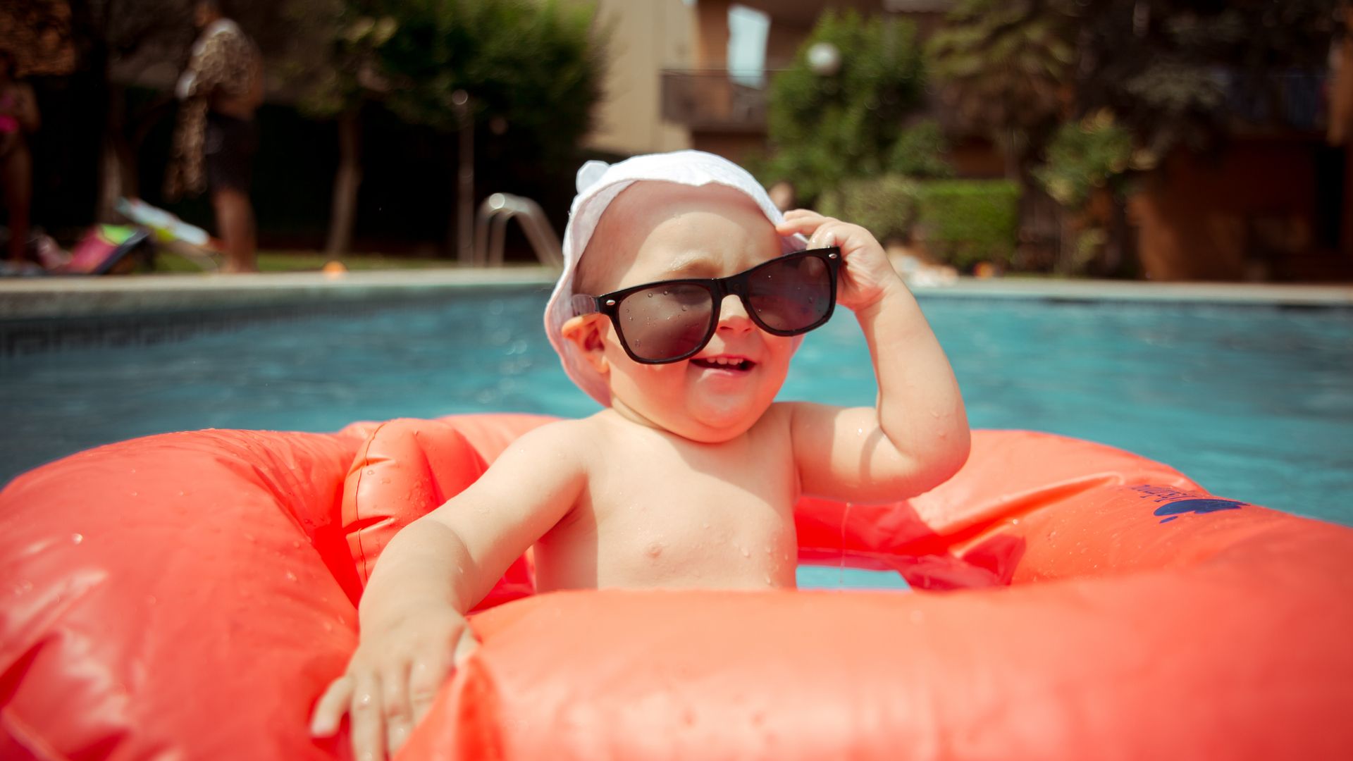 A baby boy in a rubber ring with sunglasses
