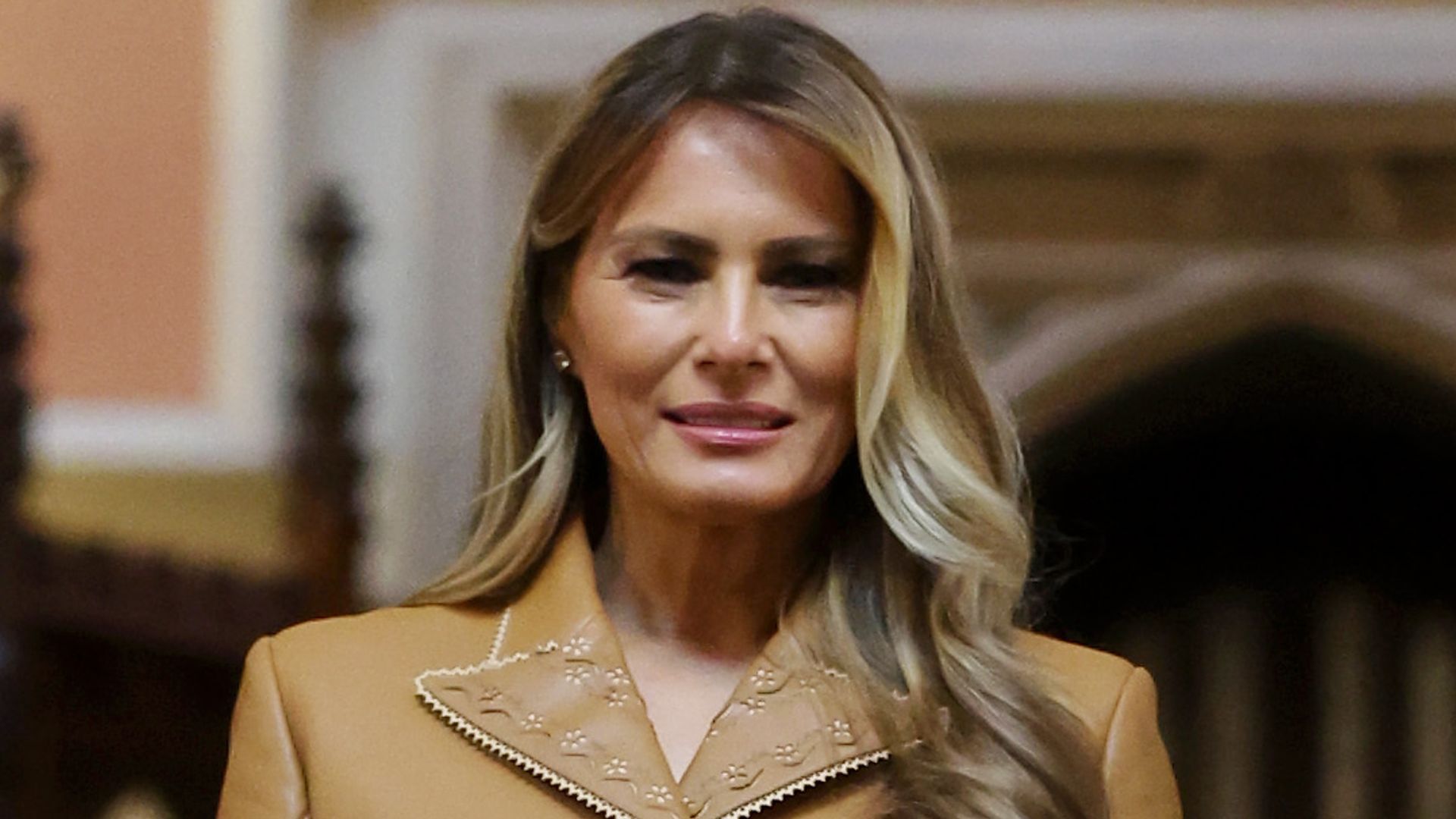 Melania Trump in beige leather suit and Queen Camilla in white dress pose together