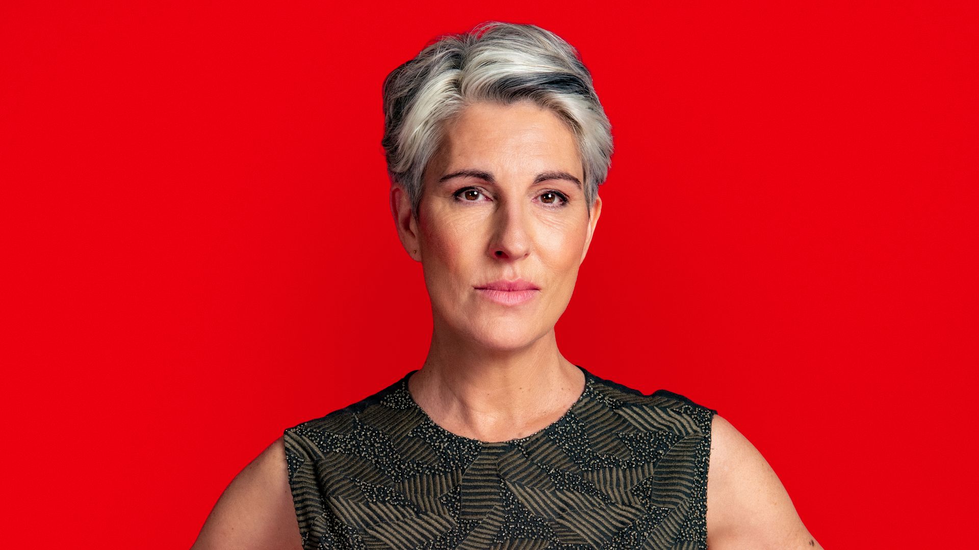 woman with hands on hips against red background