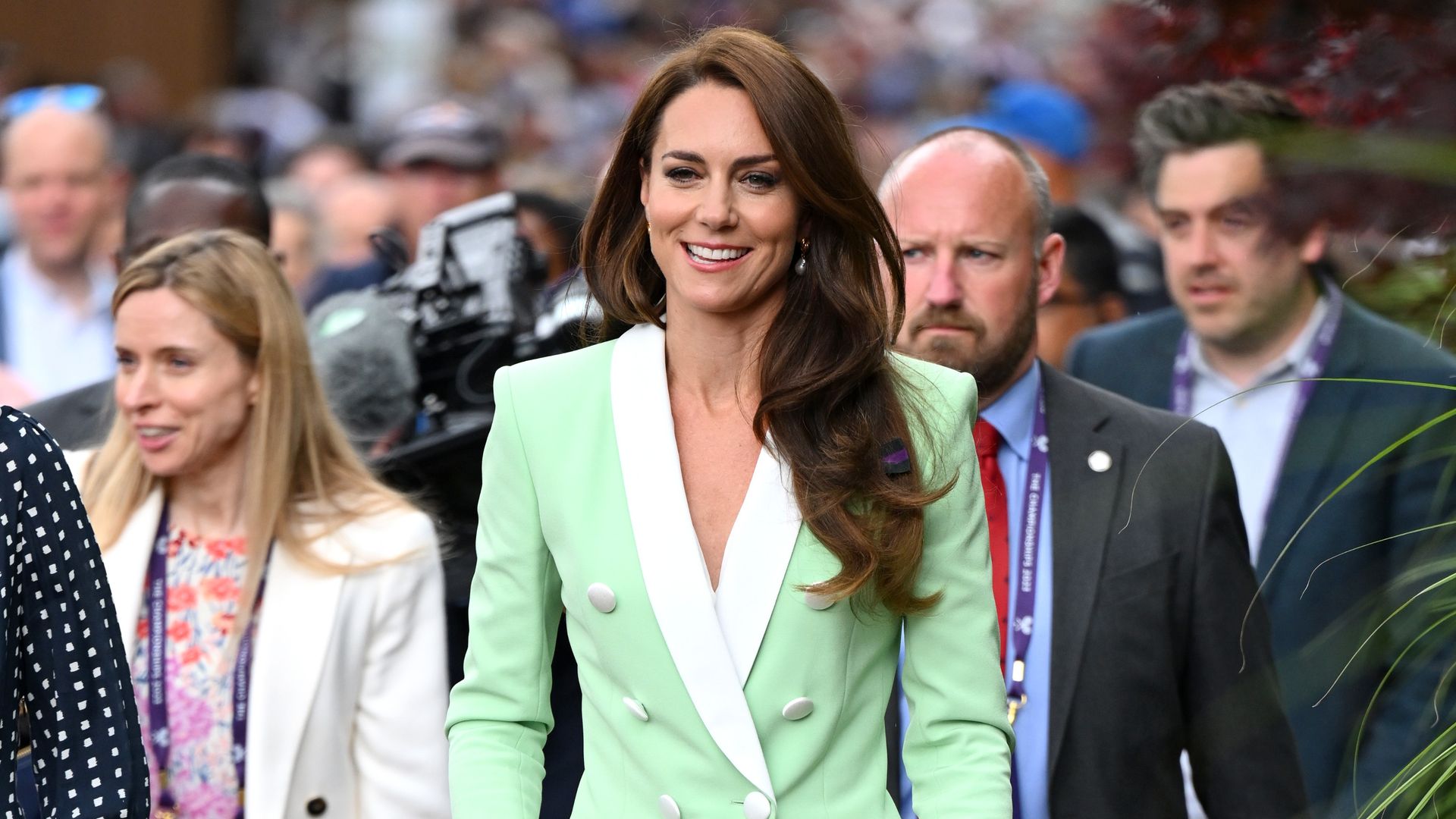 Kate Middleton wearing a green blazer with dramatic shoulder pads 