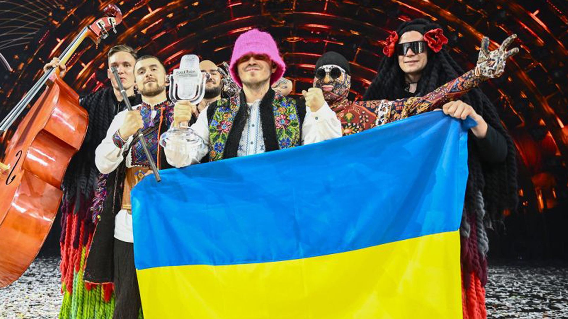 Members of the band Kalush Orchestra pose onstage with the winner's trophy and Ukraine's flags after winning in 2022