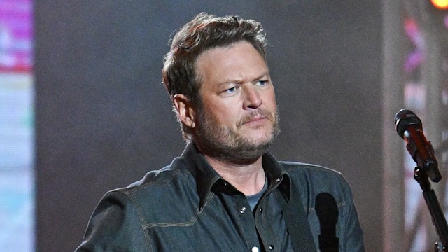 photo of blake shelton on stage holding a guitar