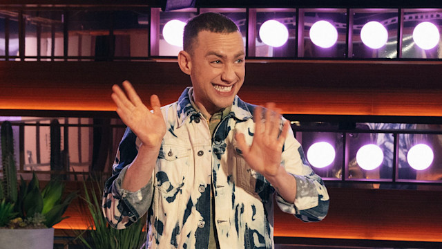 Olly Alexander waving as he approaches the stage