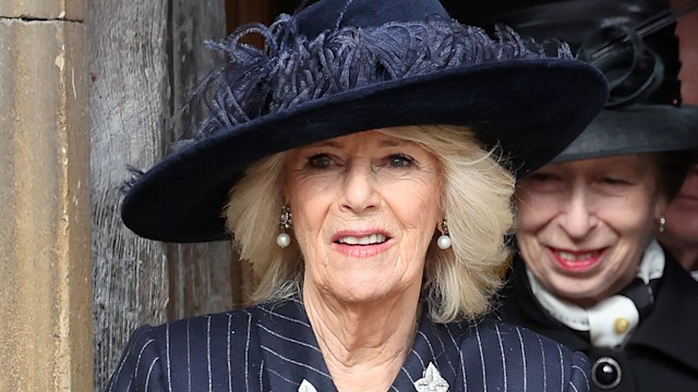 Queen Camilla in a pinstripe skirt suit and feathered hat