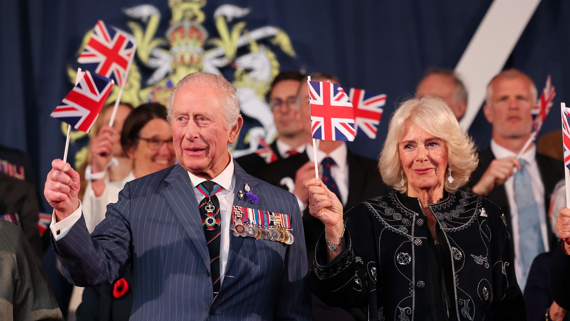 King Charles and Queen Camilla waving union flags