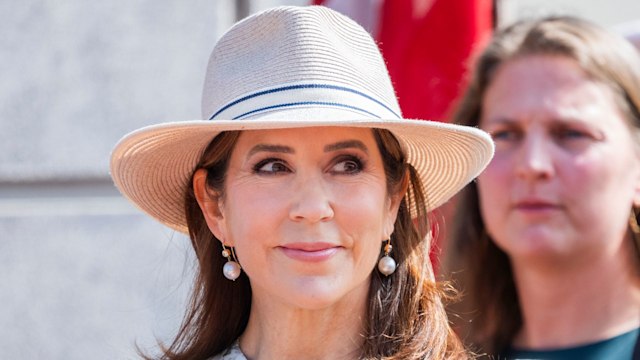 Queen Mary of Denmark holding flowers in straw hat