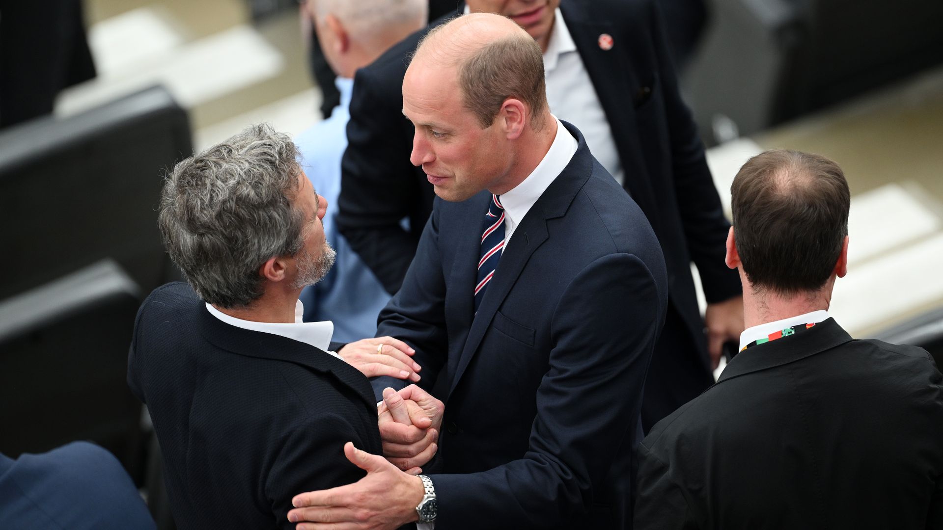 Prince William and King Frederik putting their arms around each other
