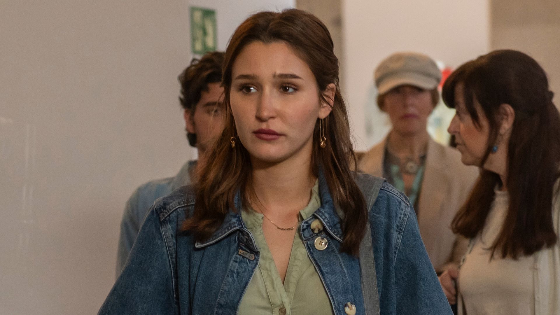young woman standing in busy hallway