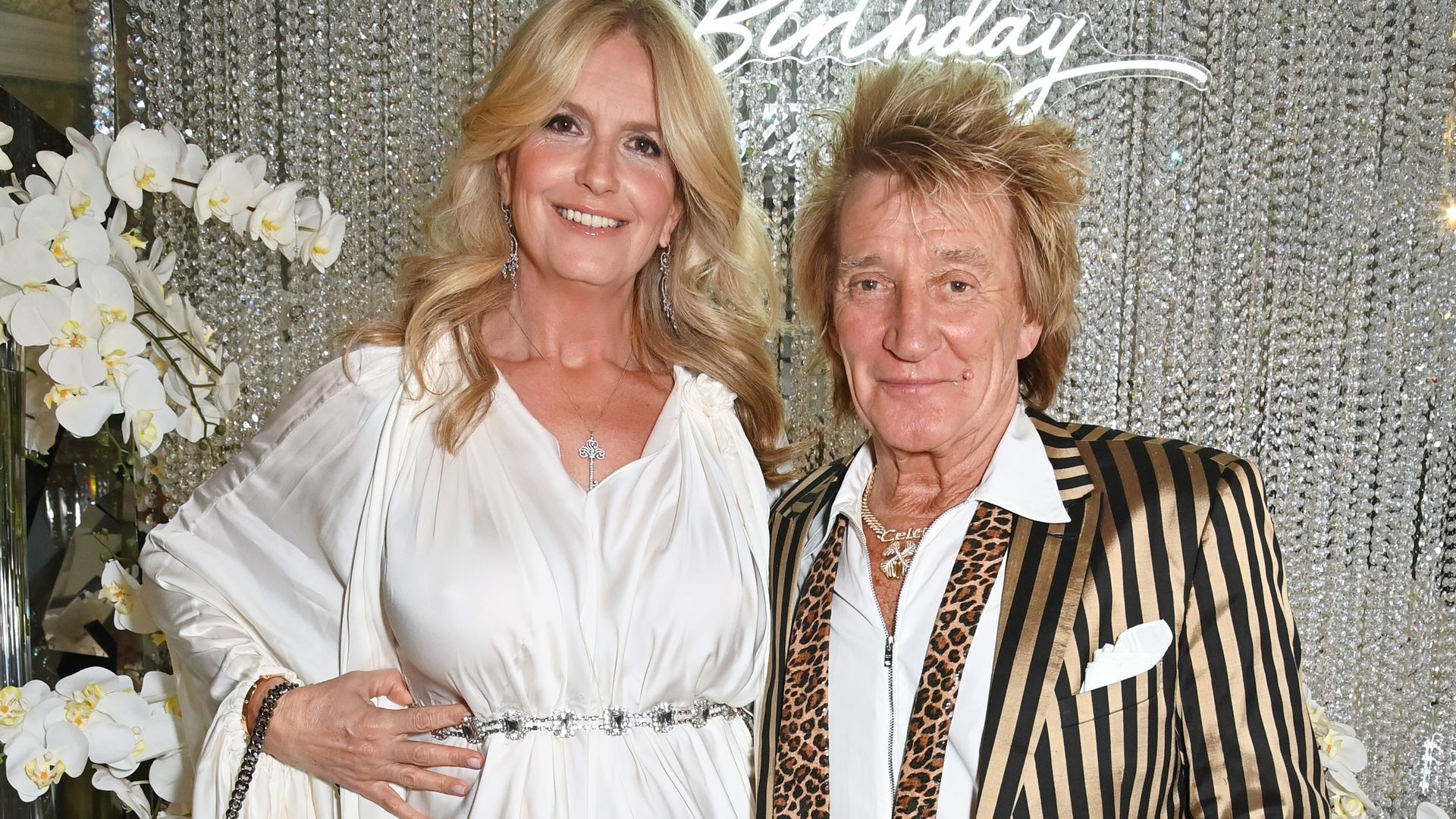 Penny Lancaster in white and Sir Rod Stewart at glitzy party