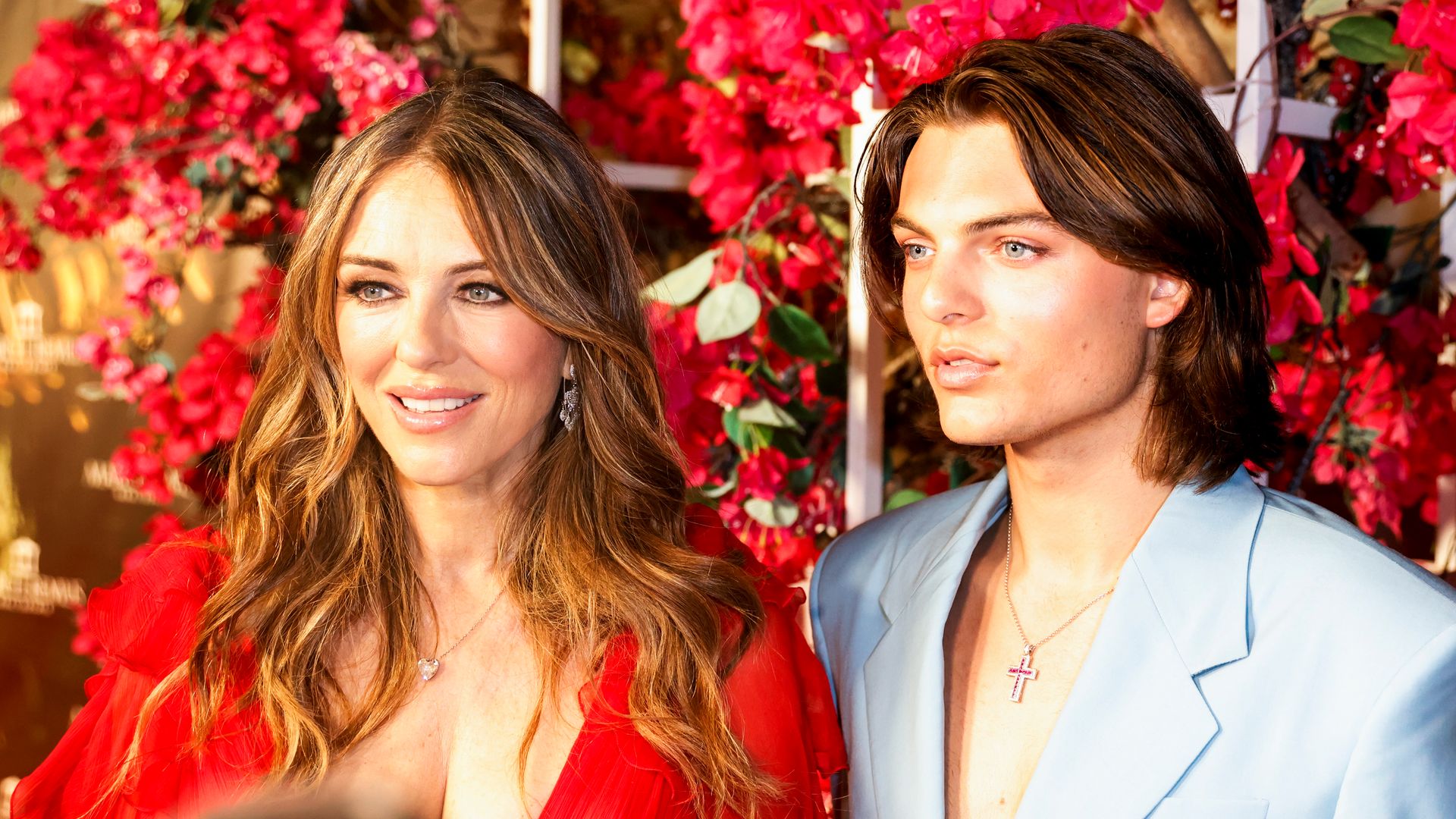 Elizabeth Hurley and Damian Hurley in front of red flowers
