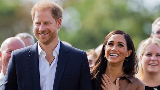 Prince Harry and Meghan Markle smiling in a group photo during the Invictus Games