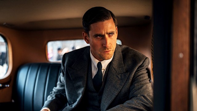 Man in suit sitting in back of car