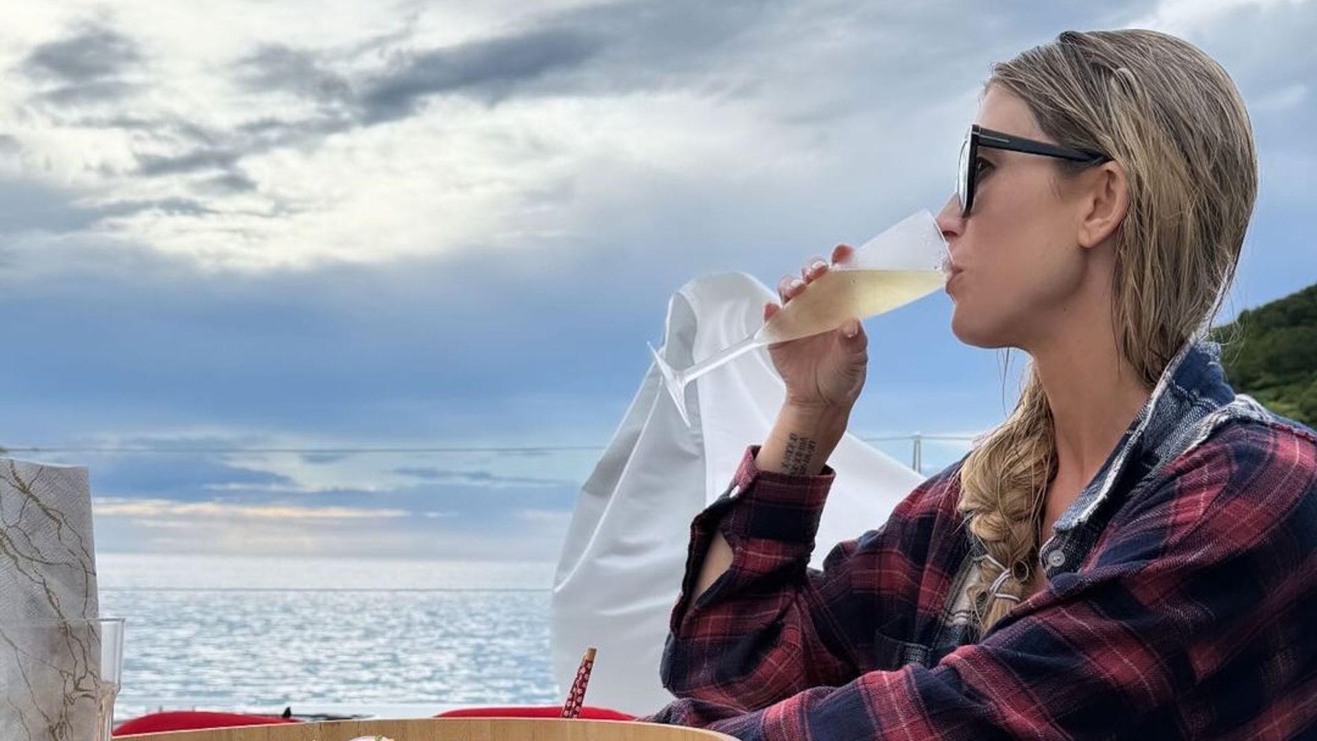 Christina Hall drinking Champagne by the ocean 