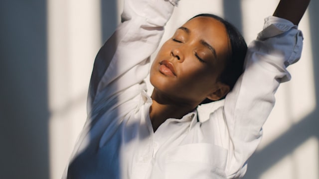 woman stretching in a white shirt 