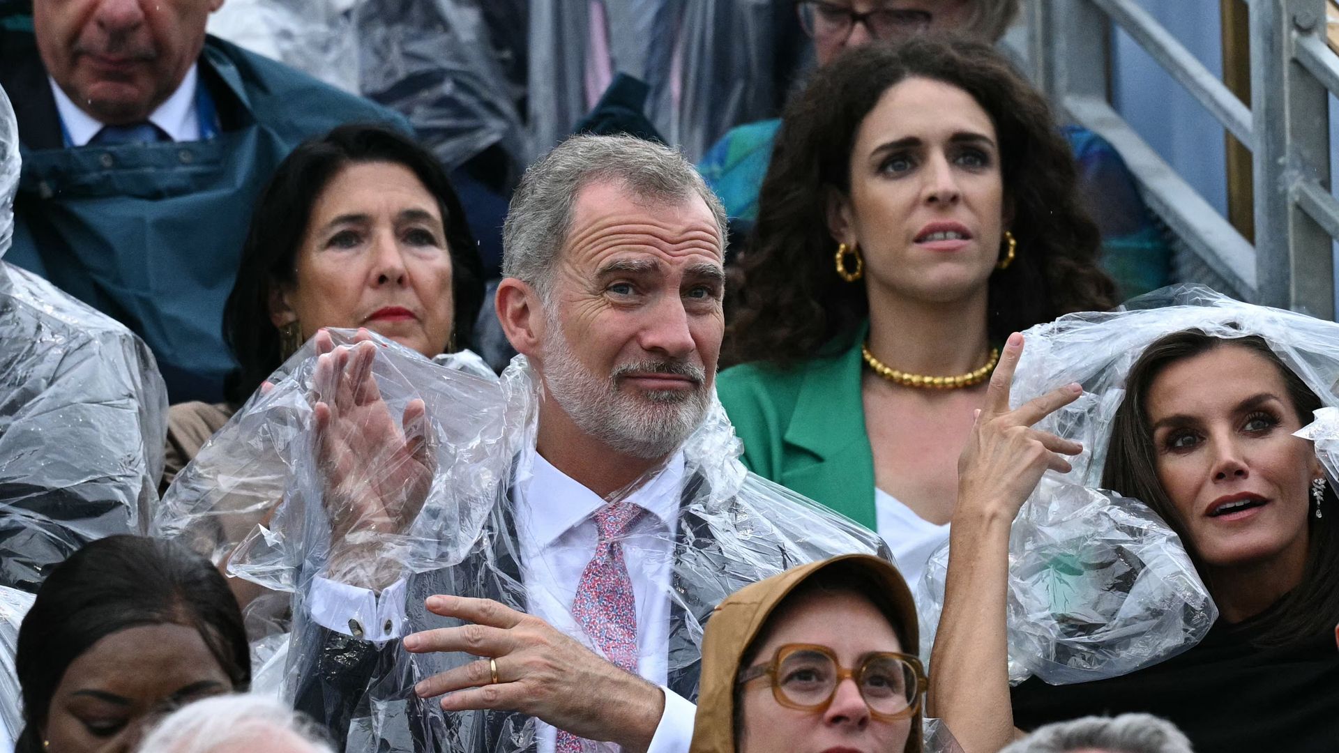 König Felipe VI. von Spanien (Mitte) und Königin Letizia von Spanien (rechts) tragen Regenkleidung während der Eröffnungszeremonie der Olympischen Spiele 2024 in Paris. 