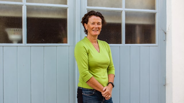 Woman in green against a blue door 