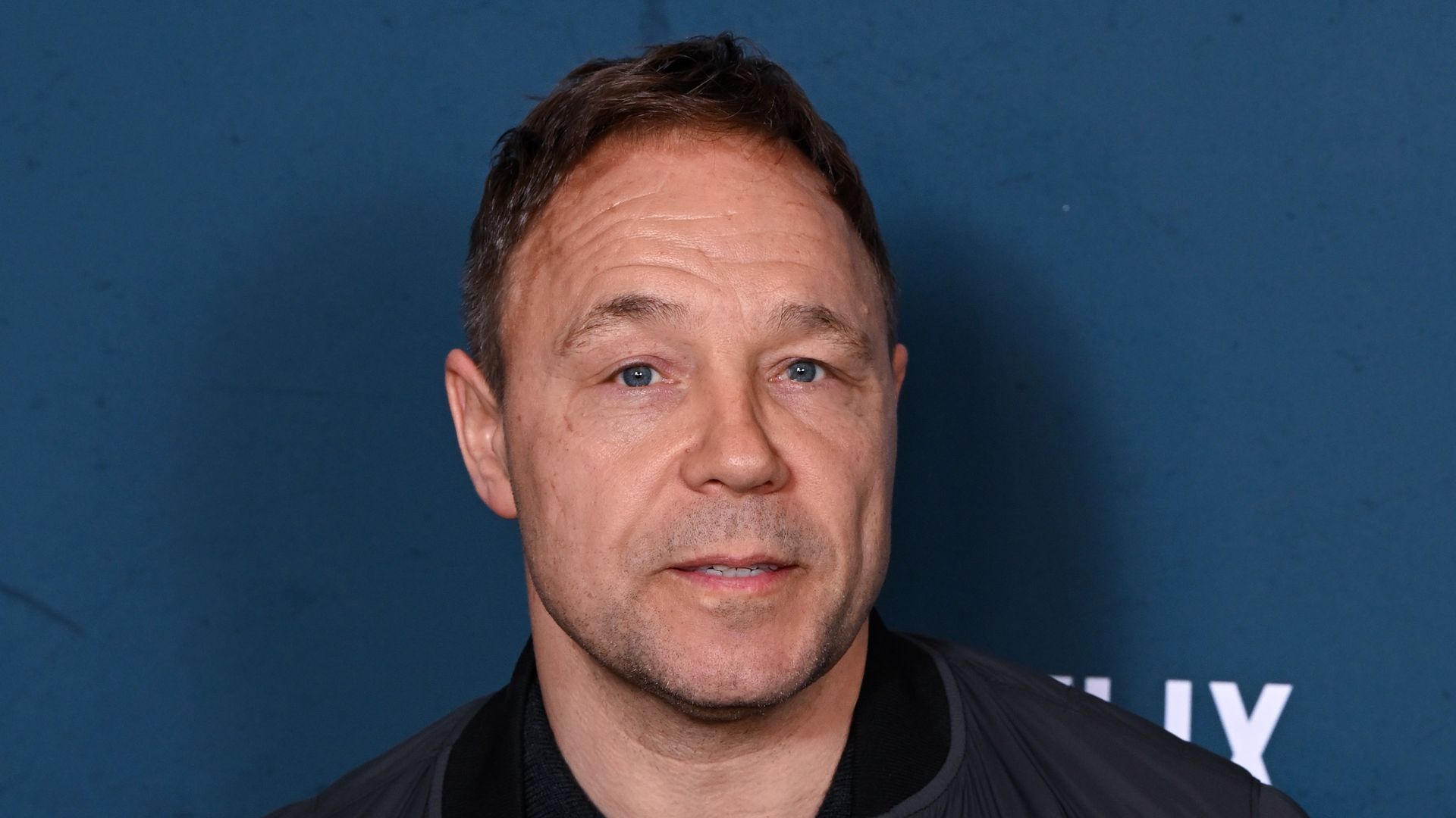 Stephen Graham in a coat and black jumper