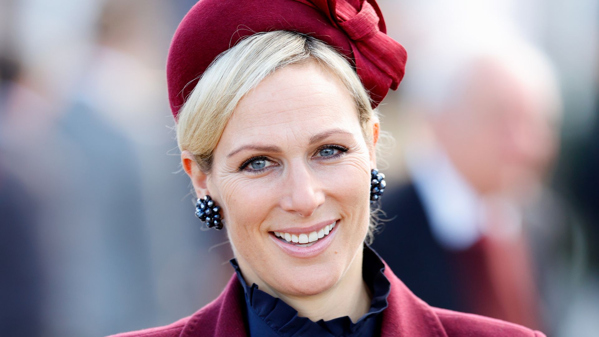 Zara Tindall in burgundy coat and fascinator