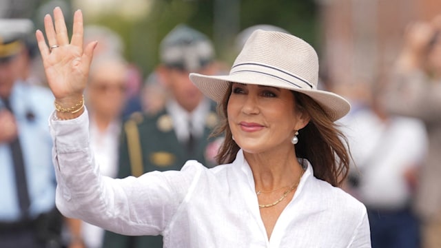 Queen Mary waves in hat and white shirt 