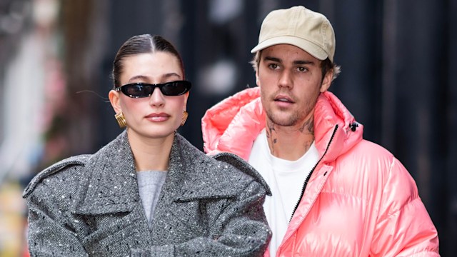 Hailey Bieber walking with her arms folded and Justin closely behind walking through NYC