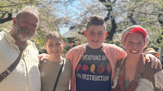 Dick and Angel Strawbridge standing with their two kids in the middle in front of a blossom tree during trip to Tokyo