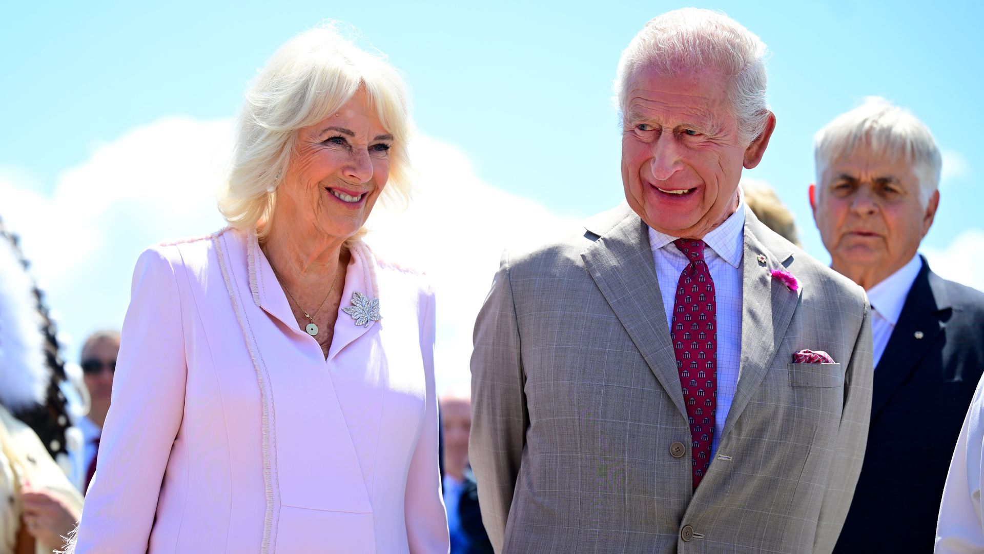Queen Camilla standing with King Charles; both are smiling