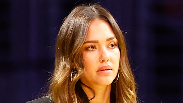 Jessica Alba looking serious in a black jacket and jeand