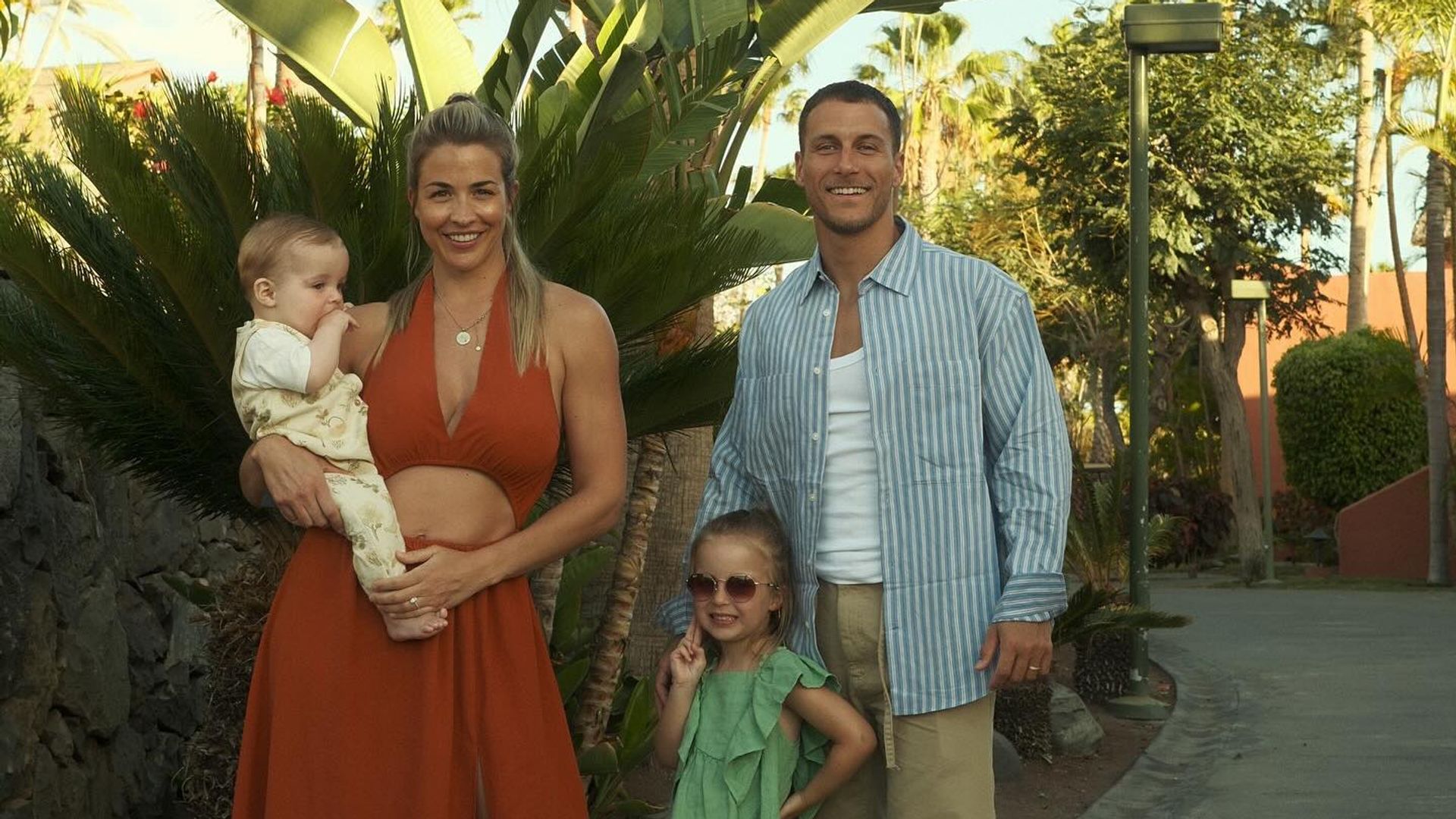 family of four posing outside in summer outfits 