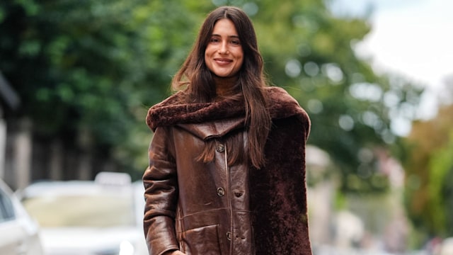 Belen Hostalet wears dark brown oversized scarf, shiny dark brown oversized leather jacket, light brown leather bag, shiny black leather boots, outside Alberta Ferretti, during the Milan Fashion Week Spring/Summer 2024-2025 on September, 2024 in Milan, Italy. (Photo by Edward Berthelot/Getty Images)