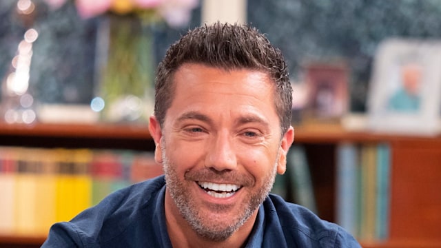 gino d'acampo smiling on sofa