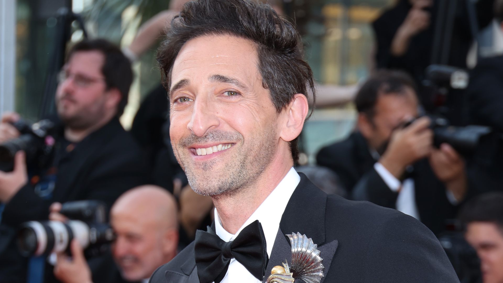 Adrien Brody smiling at a red carpet event