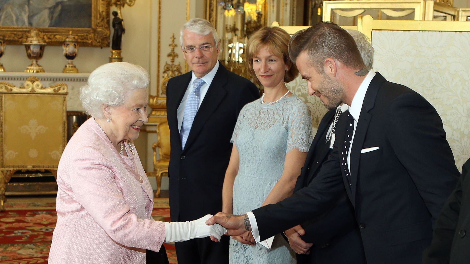 The late Queen shaking hands with David Beckham
