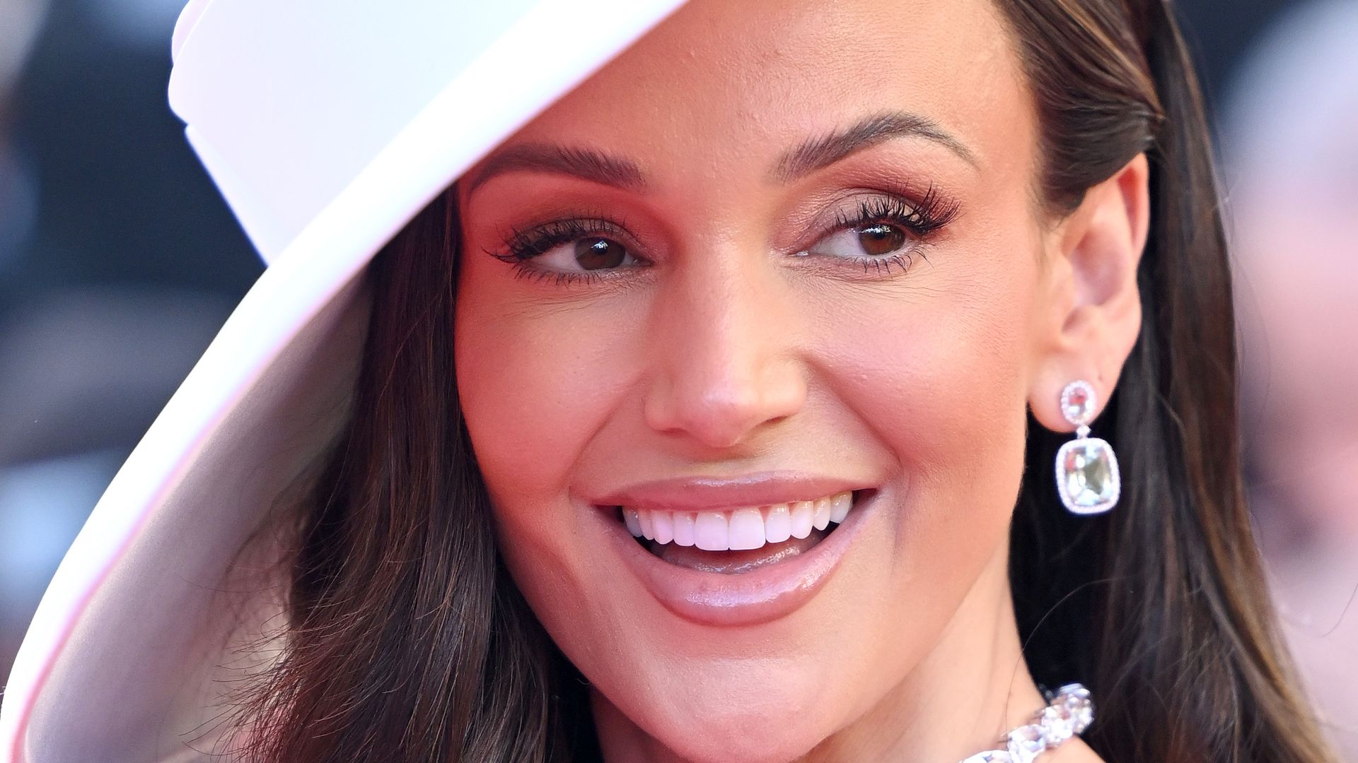 Michelle Keegan smiling in white hat