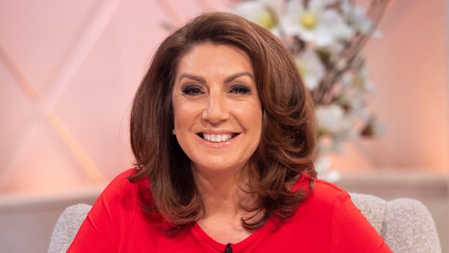 Jane McDonald in a red jumper and white trousers