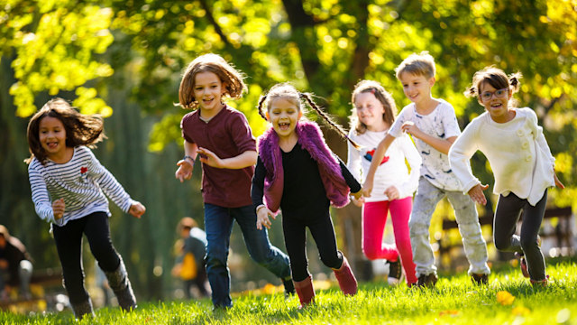 Half term activities - Group of school children running on school playground