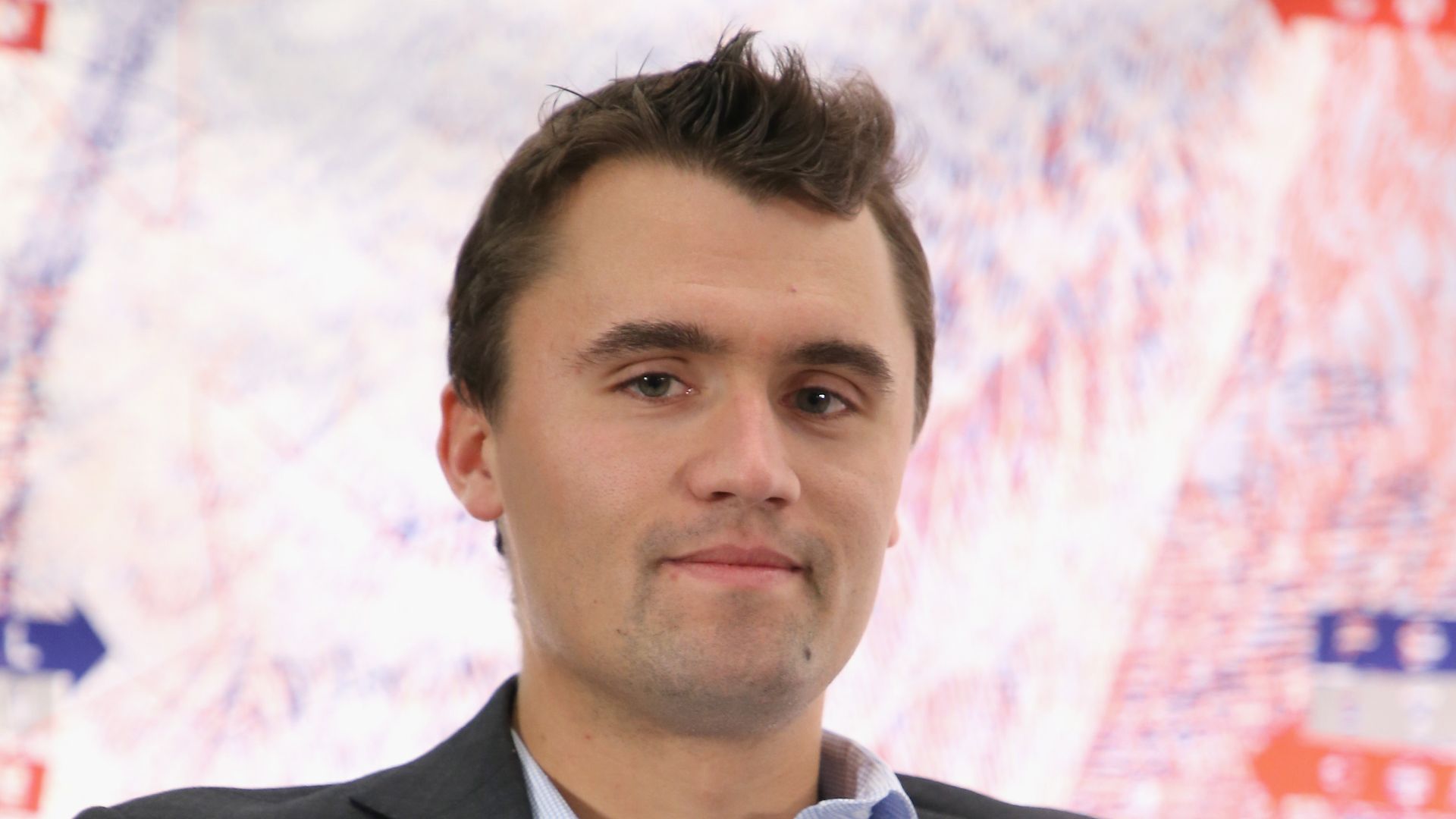 Charlie Kirk at political event wearing a blazer and shirt