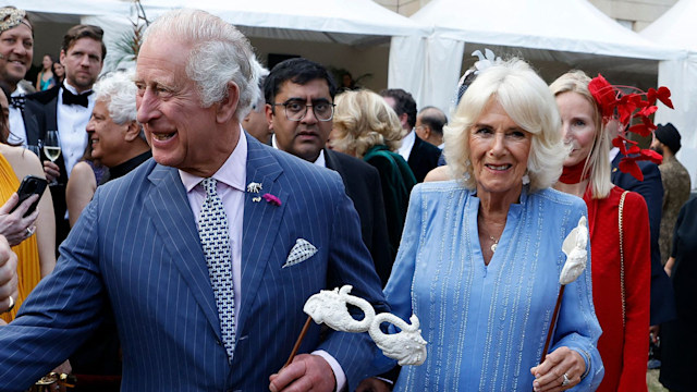 Britain's King Charles III and Britain's Queen Camilla hold masks as they attend the Animal Ball at Lancaster House in London 