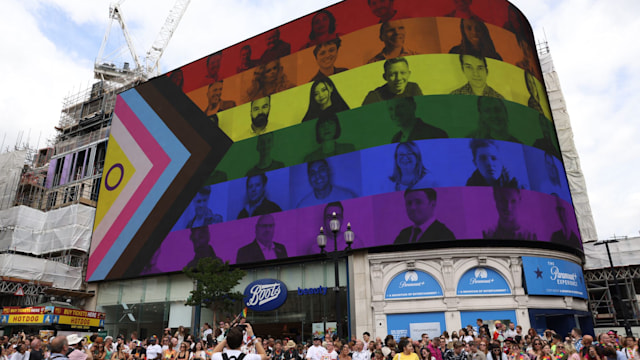 A billboard featuring the Pride Progress flag