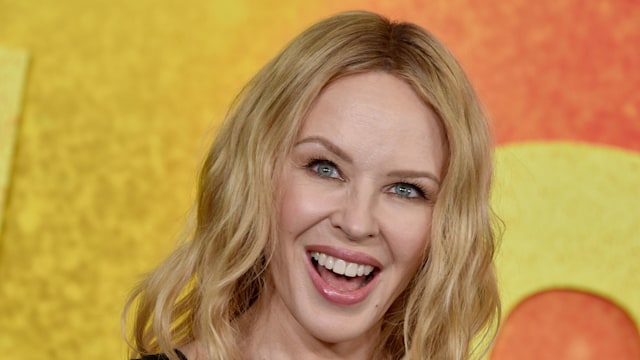 Kylie Minogue smiling in a black dress