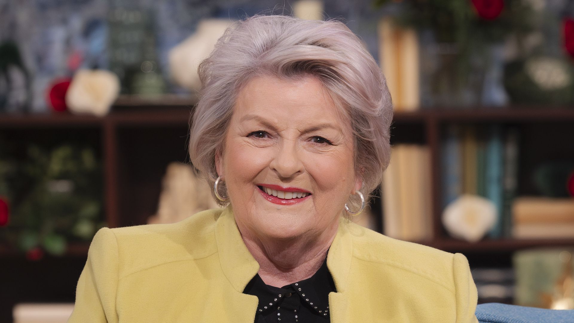 close-up of woman sitting on blue sofa in tv studio