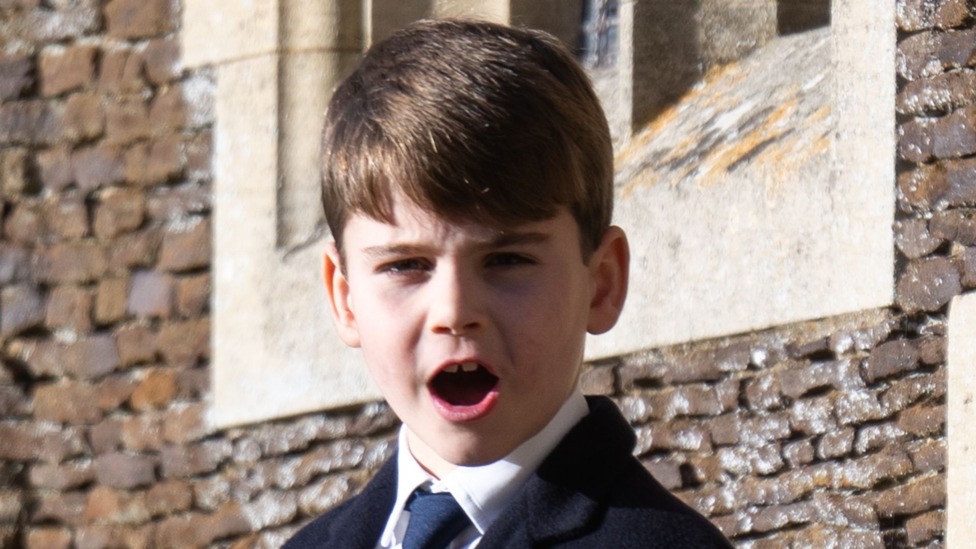 Prince Louis of Wales standing outside church with mouth wide open