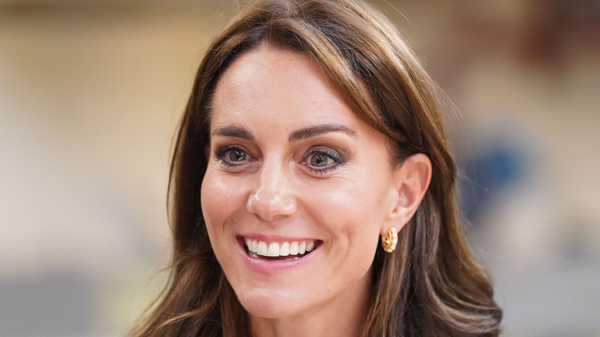 Catherine, Princess of Wales smiling in green suit