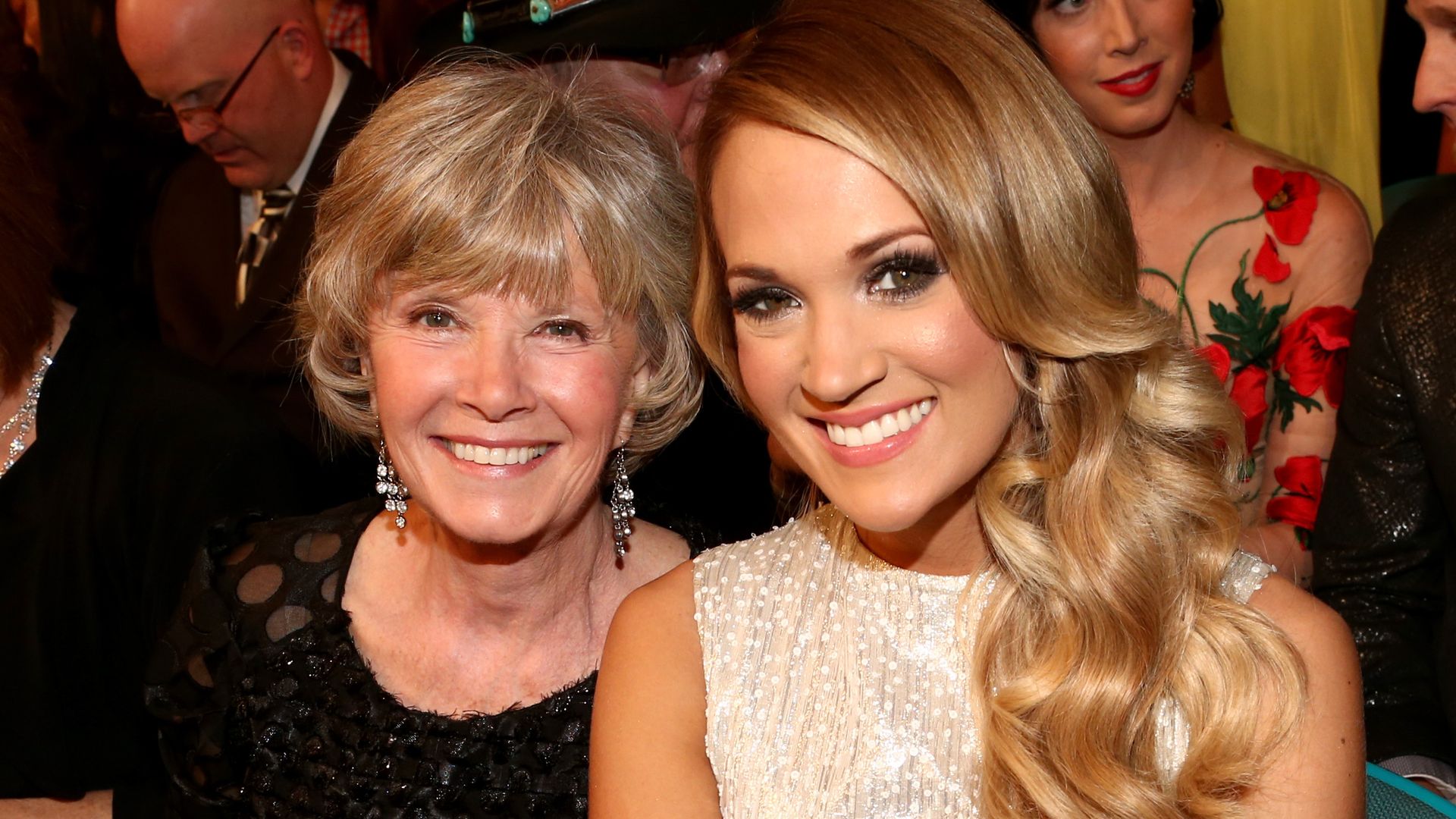 Carrie Underwood and her mom Carole smiling while sat at an awards show
