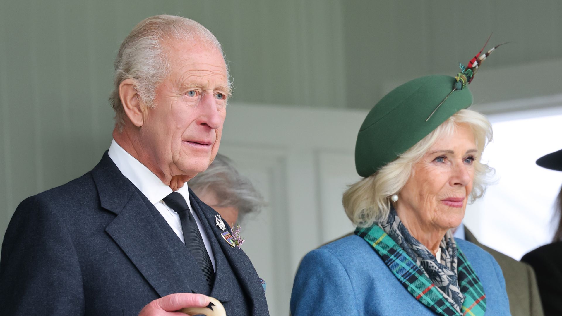 King Charles and Queen Camilla looking solemn