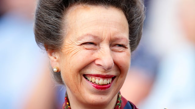 The Princess Royal smiling in red coat