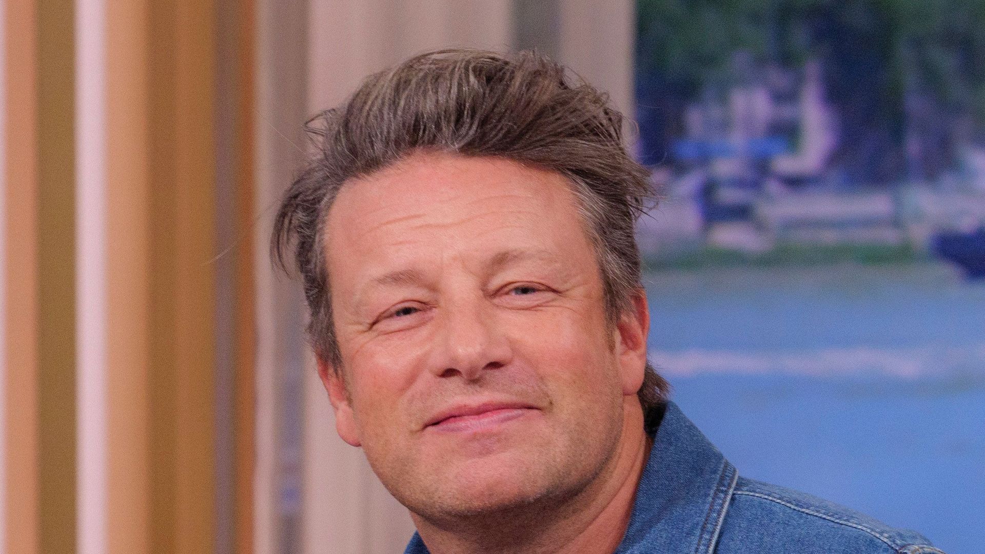 man in denim shirt on sofa