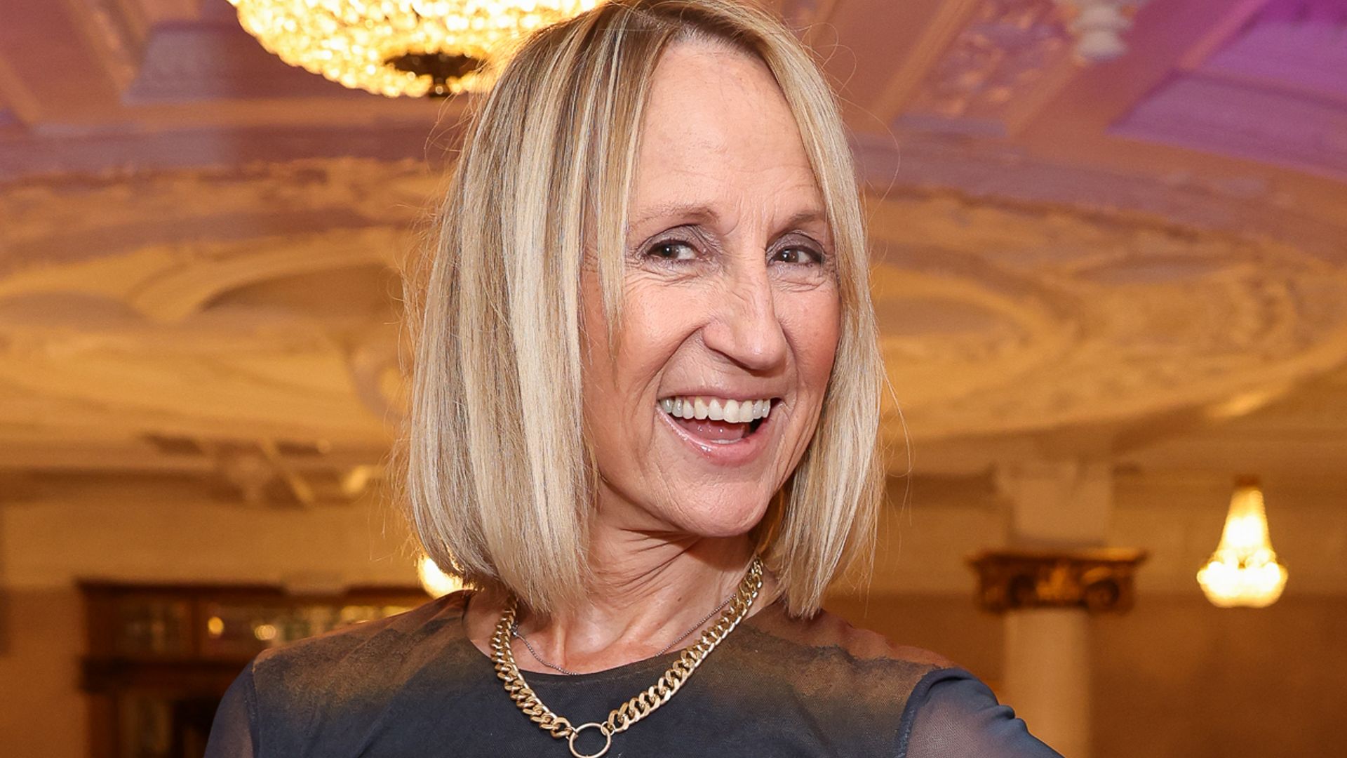 Carol McGiffin smiling with a glass of champagne