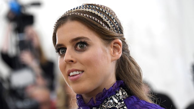 Princess Beatrice at the Met Gala in 2018 wearing a purple dress and headbands